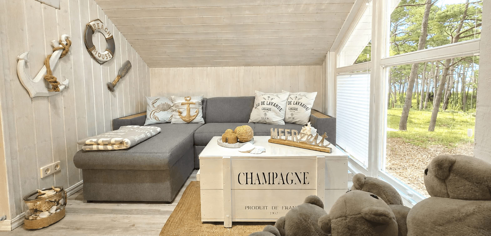 Gemütliche Sitzecke auf der Galerie mit freiem Meerblick, großer Fensterfront und Blick in den Kiefernwald. Der einzigartige Teddysessel, das Schlafsofa, sowie die maritime Einrichtung schaffen einen besonderen Rückzugsort zum Entspannen und Wohlfühlen.