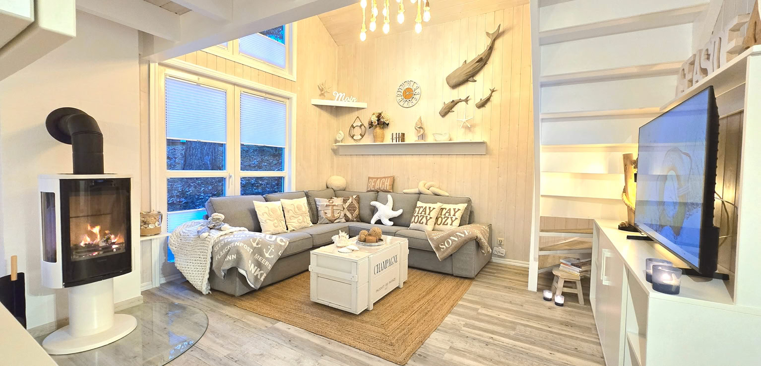 Wohnzimmer mit pink Sofas, einem Couchtisch, einem Fernseher, einer Treppe und einem offenen Obergeschoss.